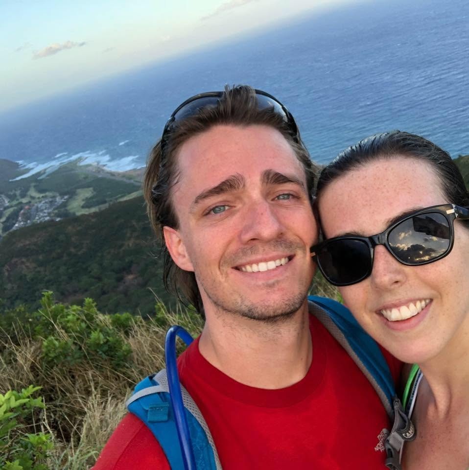 Two people outdoors with a coastal landscape in the background